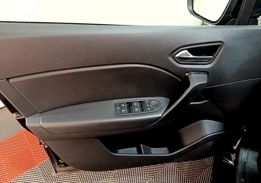 Vue intérieure côté gauche de la porte avant noire du Renault Captur 2021 avec commandes électriques des vitres et poignée intégrée.