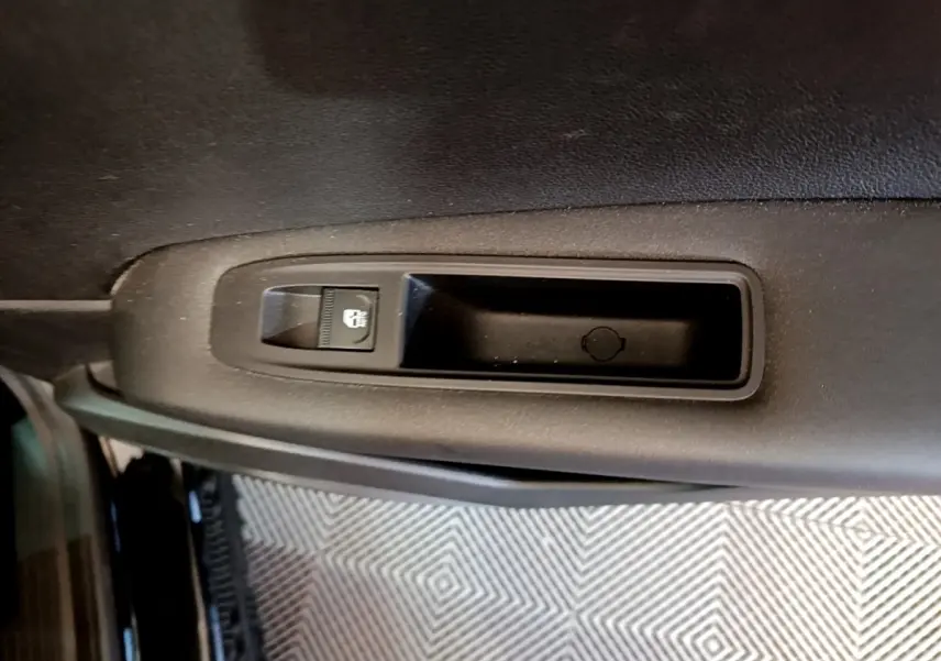 Gros plan sur la commande de verrouillage de porte intérieure noire du côté gauche d’un Renault Captur noir 2021.