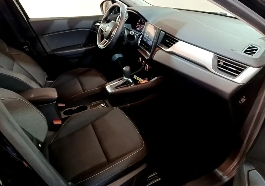 Vue intérieure côté conducteur du Renault Captur Business 2021, sièges noirs et tableau de bord avec écran tactile central.