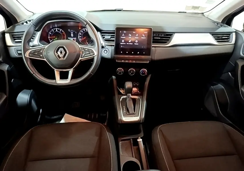 Vue intérieure avant du Renault Captur noir 2021, tableau de bord avec écran tactile central et volant multifonctions.