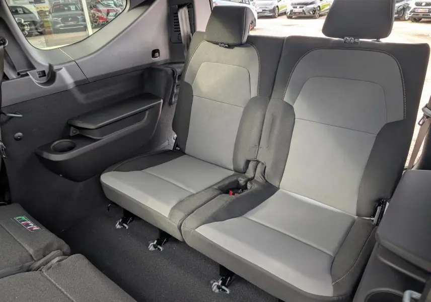 Vue intérieure sur la banquette arrière grise et noire du Dacia Jogger 2025, côté droit avec tablette et porte-gobelet.