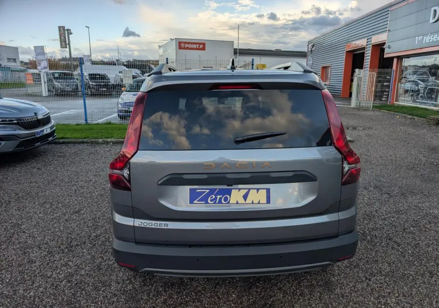 Vue arrière d’un Dacia Jogger gris métallisé avec logo brun cuivré et feux verticaux distinctifs.