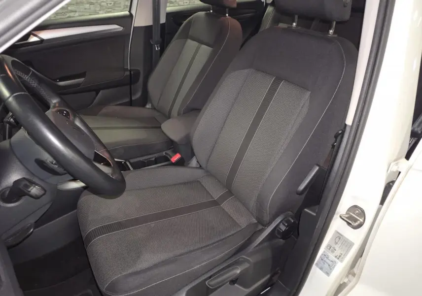 Vue intérieure côté conducteur du Volkswagen T-Roc blanc 2022, mettant en valeur les sièges en tissu noir et gris.