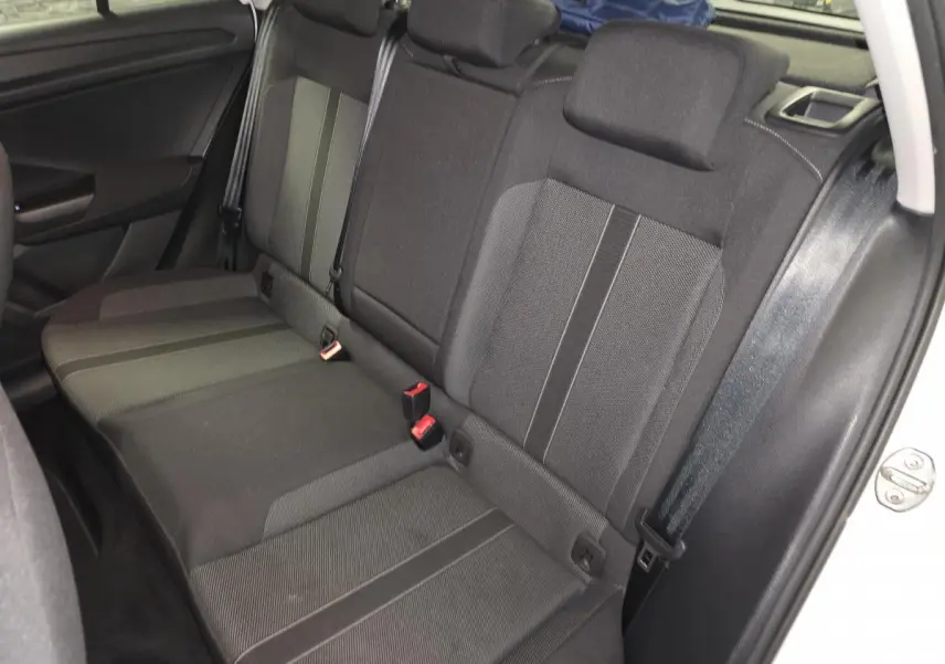 Banquette arrière en tissu gris foncé du Volkswagen T-Roc blanc, vue côté droit avec ceintures de sécurité visibles.