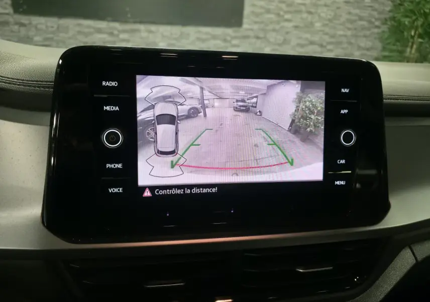 Écran tactile intérieur du Volkswagen T-Roc blanc montrant la caméra de recul avec guidage de trajectoire.