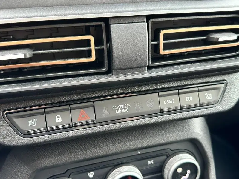 Gros plan sur la console centrale du Dacia Jogger 2025, boutons de contrôle et aérateurs noirs avec liseré beige.