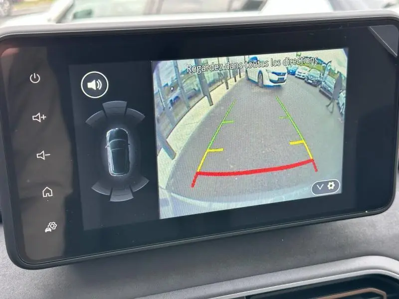 Écran tactile intérieur montrant la caméra de recul du Dacia Jogger 1.6 hybrid noir nacré, avec lignes de guidage colorées.