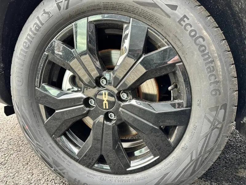 Gros plan sur la jante alu noire nacrée du Dacia Jogger 1.6 hybrid 140ch Extreme avec logo DACIA au centre.