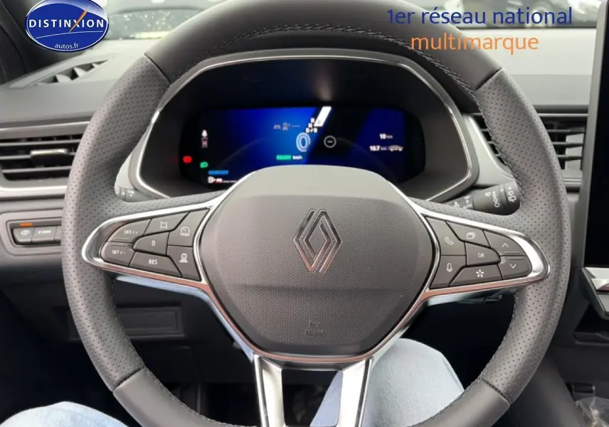 Vue rapprochée du volant en cuir perforé gris d’une Renault Symbioz 2026 avec tableau de bord numérique allumé.