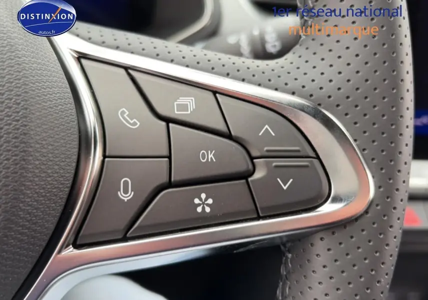 Gros plan sur les commandes multifonctions noires et chrome du volant perforé du Renault Symbioz gris schiste.