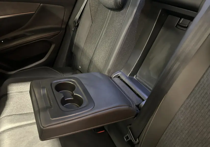 Vue intérieure côté droit des sièges arrière noirs du Peugeot 3008 GT Line 2020 avec accoudoir central et porte-gobelets déployés.