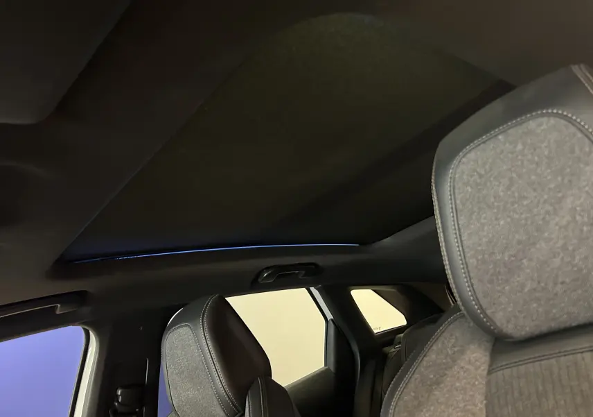 Vue intérieure du toit ouvrant et des sièges avant en tissu gris du Peugeot 3008 GT Line 2020.