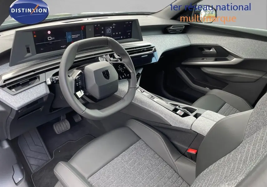 Intérieur moderne du Peugeot 3008 Hybrid 2025, vue côté conducteur, avec tableau de bord numérique et sièges gris tissu et cuir.