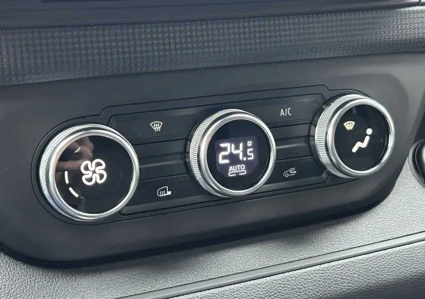 Gros plan sur les commandes de climatisation digitale du Renault Trafic Fourgon 2025, affichant 24,5°C en mode automatique.