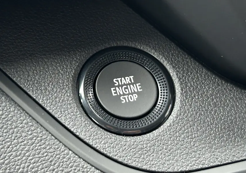 Gros plan sur le bouton Start Engine Stop noir dans l’habitacle du Renault Trafic Fourgon gris Comète.
