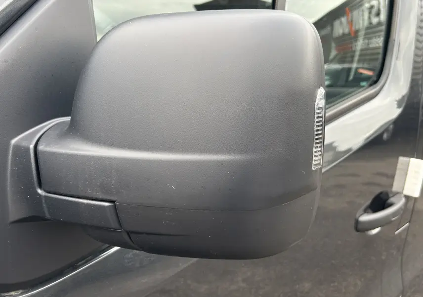 Rétroviseur droit noir mat du Renault Trafic Fourgon gris Comète, vue rapprochée sur la porte avant.