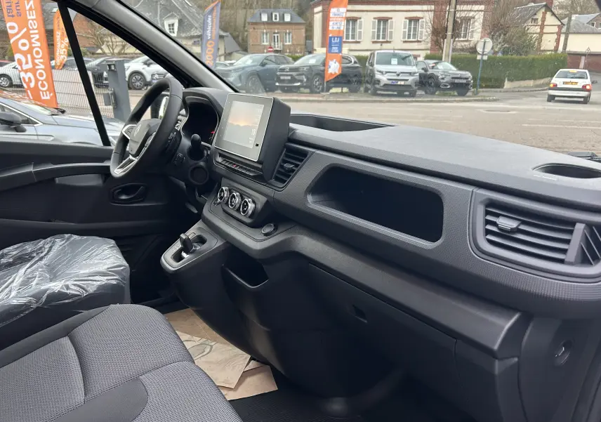 Vue intérieure côté conducteur du Renault Trafic Fourgon 2025, montrant le tableau de bord moderne et l’écran tactile central.