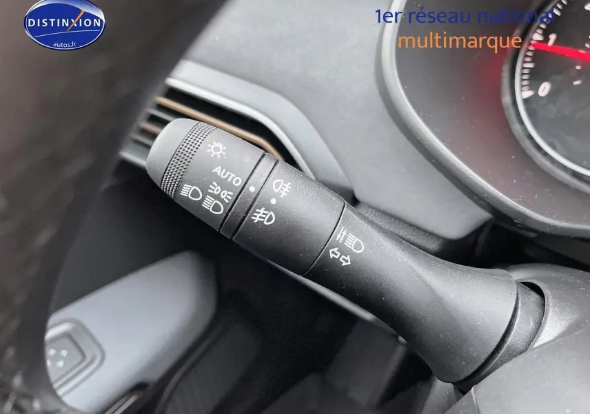 Gros plan sur la commande des phares et clignotants du tableau de bord d’un Dacia Jogger blanc 2025.