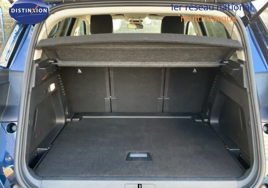 Coffre ouvert vu de l'arrière d'un Citroën C5 Aircross bleu Eclipse Metal, montrant l'espace de chargement et la tablette cache-bagages.