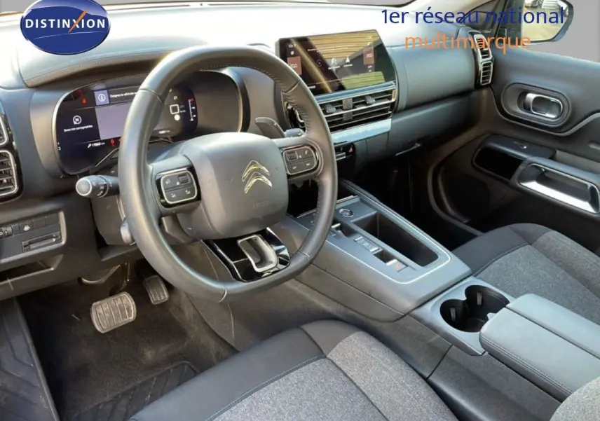 Intérieur du Citroën C5 Aircross 2025, vue côté conducteur, tableau de bord moderne avec écran tactile et volant cuir noir.