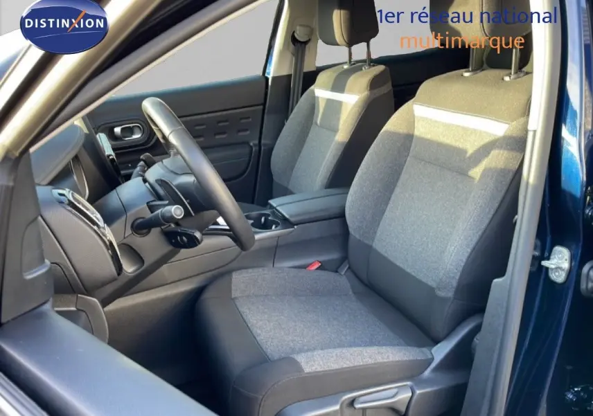Vue intérieure côté conducteur du Citroën C5 Aircross bleu Eclipse Métal, mettant en valeur les sièges tissu gris et la console centrale.