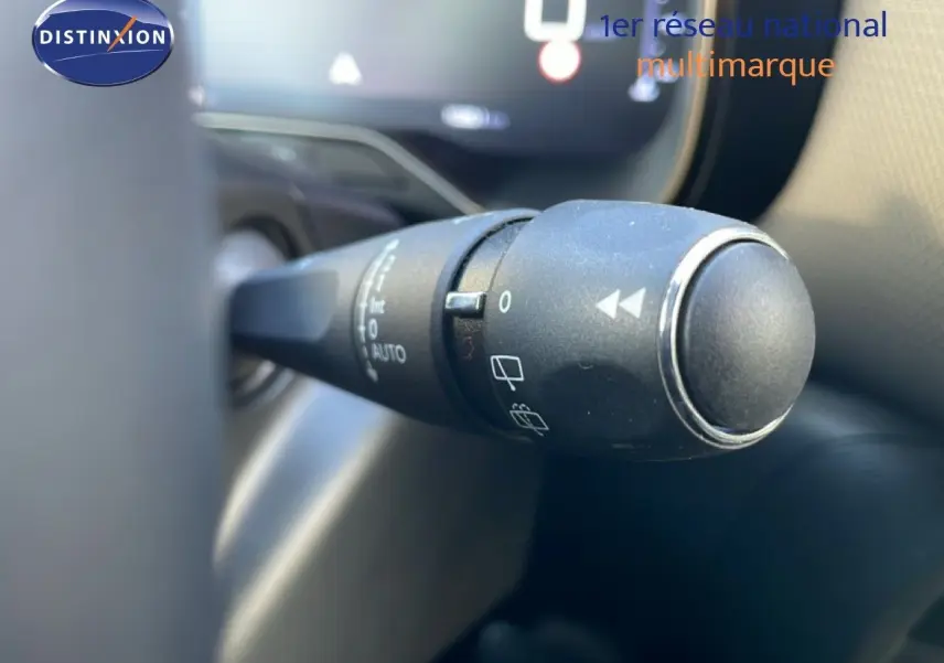 Gros plan sur la commande de l'essuie-glace du Citroën C5 Aircross 2025, intérieur noir avec tableau de bord numérique flou.