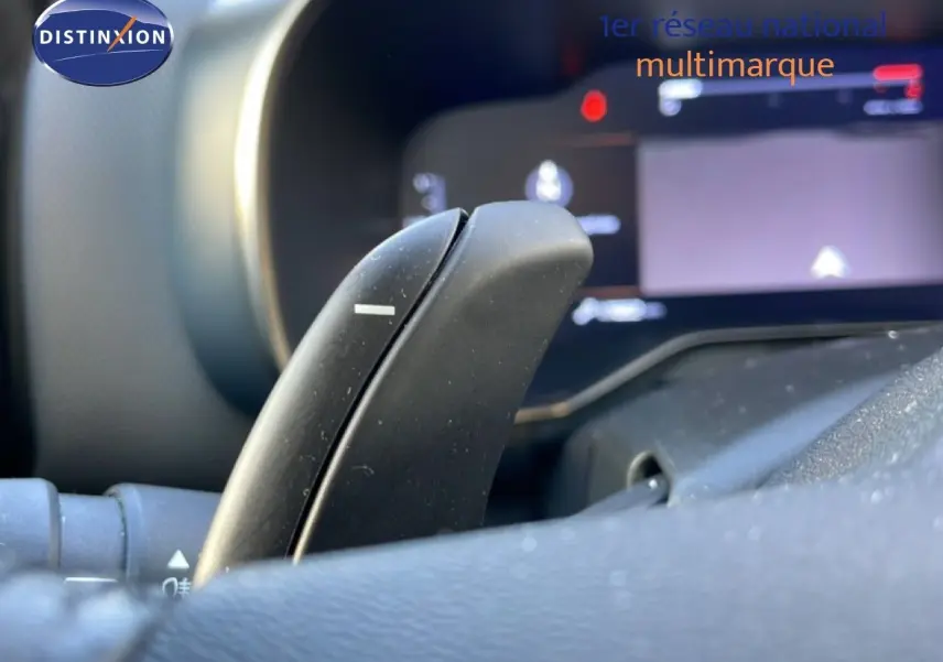 Gros plan sur la palette de changement de vitesse au volant du Citroën C5 Aircross bleu Eclipse Metal, tableau de bord flou en arrière-plan.