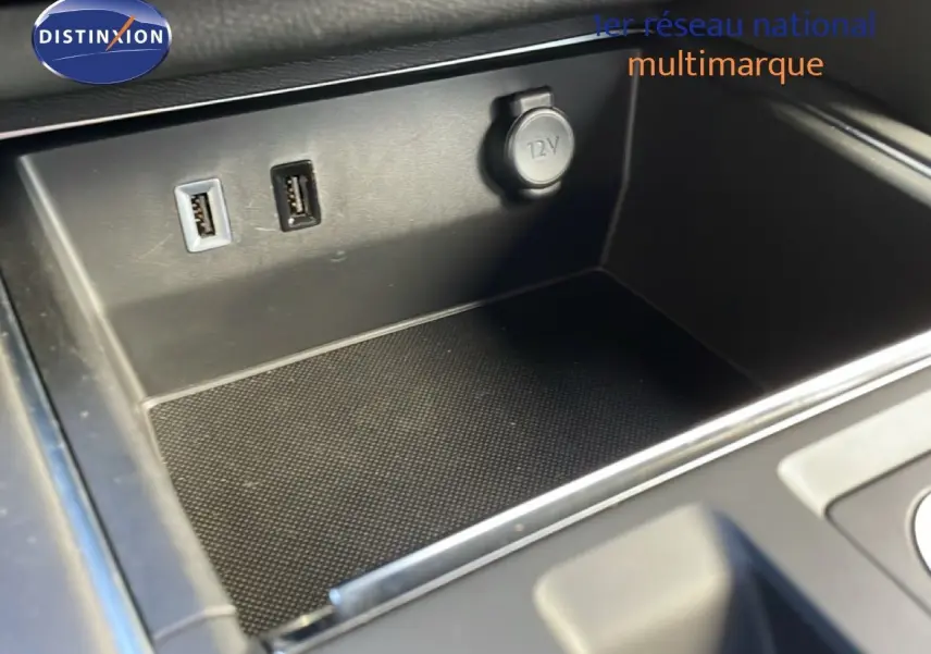 Gros plan sur la console centrale du Citroën C5 Aircross 2025, montrant prises USB et prise 12V dans un intérieur noir.