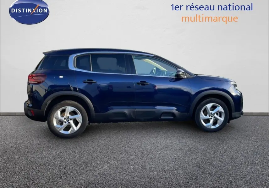 Vue de profil côté gauche d'un Citroën C5 Aircross bleu Eclipse métal, avec protections noires sur les bas de caisse.