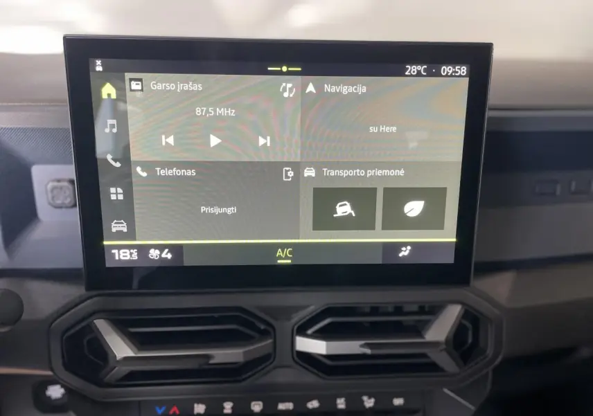 Vue rapprochée de l’écran tactile central et des aérateurs gris acier du tableau de bord du Dacia Duster beige 2025.