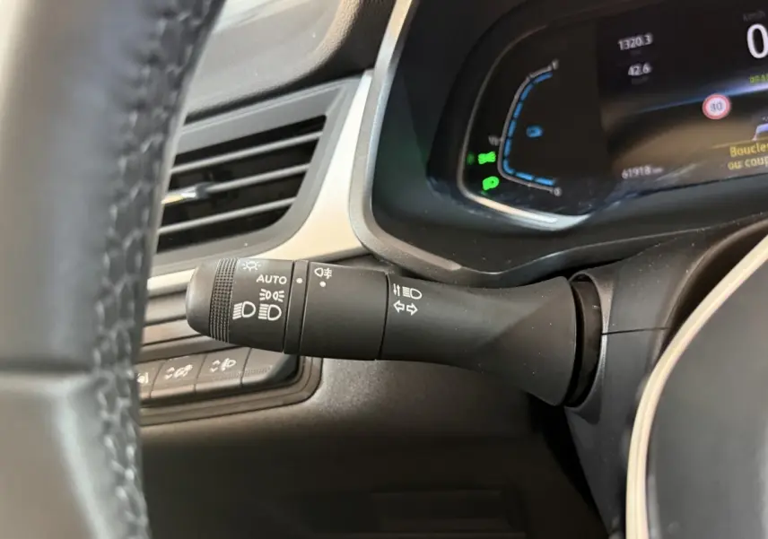 Gros plan sur la commande des phares à gauche du volant dans l'habitacle du Renault Captur bleu 2024.