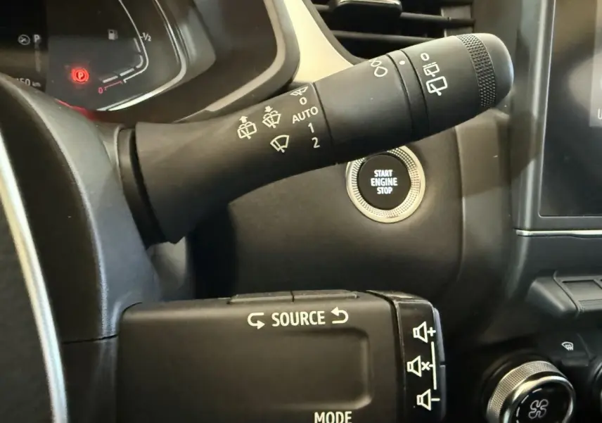 Gros plan sur commandes au volant et bouton démarrage du tableau de bord noir du Renault Captur bleu hybride 2024.