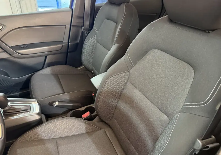 Vue intérieure côté avant droit des sièges tissu gris avec coutures blanches et levier de boîte automatique Renault Captur 2024.