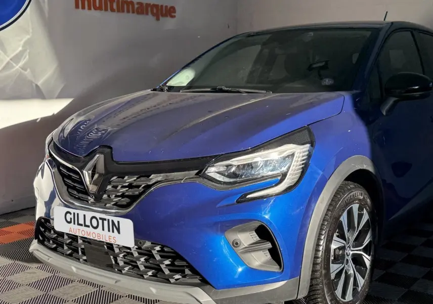 Vue 3/4 avant droit du Renault Captur bleu 2024 avec calandre noire et phares LED distinctifs.