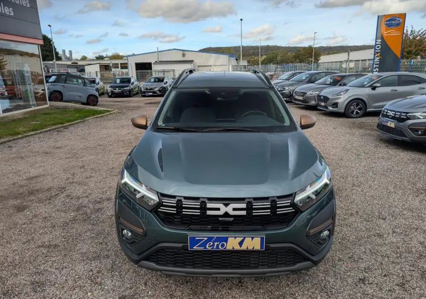 Vue avant frontale du Dacia Jogger 2025 vert métallisé avec calandre noire et phares LED allumés.