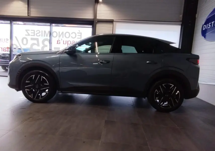 Vue latérale droite d'un Peugeot 3008 2025 hybride en bleu métallisé avec jantes alliage noires brillantes.