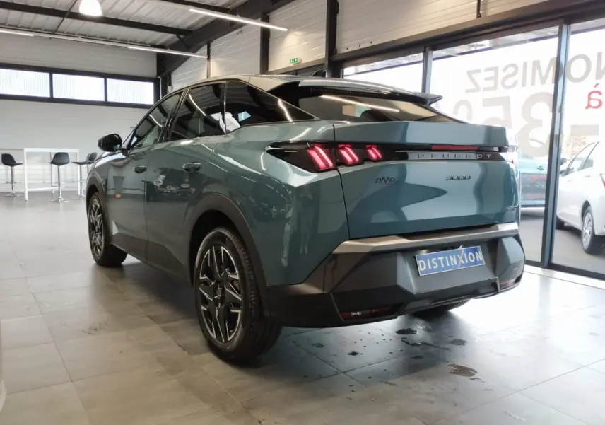 Vue 3/4 arrière droite du Peugeot 3008 hybride bleu métallisé avec feux arrière LED à 3 griffes et jantes alliage noires.