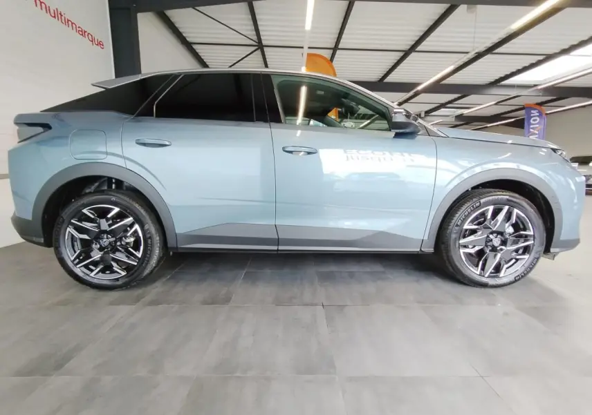 Profil côté gauche du Peugeot 3008 hybride bleu Azul 2025 avec jantes alliage 19 pouces et vitres teintées.