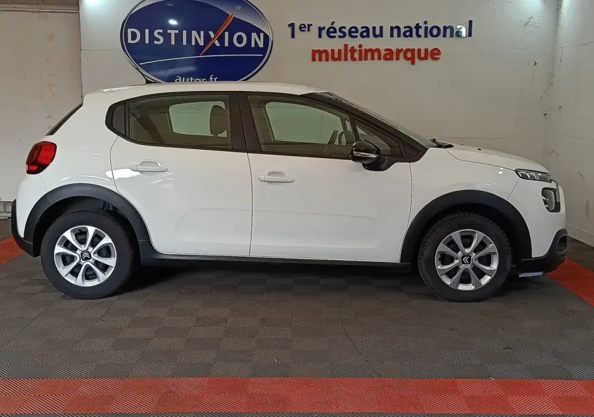 Profil côté gauche d'une Citroën C3 blanche 2020 avec jantes alliage et protections noires sur les passages de roues.