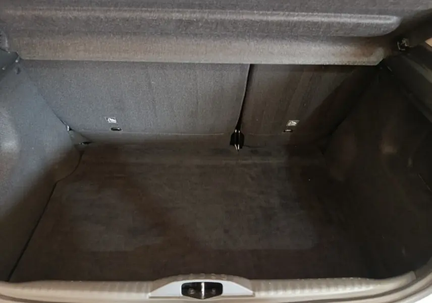Coffre ouvert vu de face, intérieur noir, banquette arrière rabattue partiellement, Citroën C3 blanc 2020.