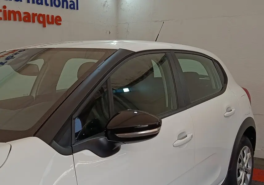 Vue côté gauche d'une Citroën C3 blanche 2020 avec rétroviseur noir et poignées de porte assorties.