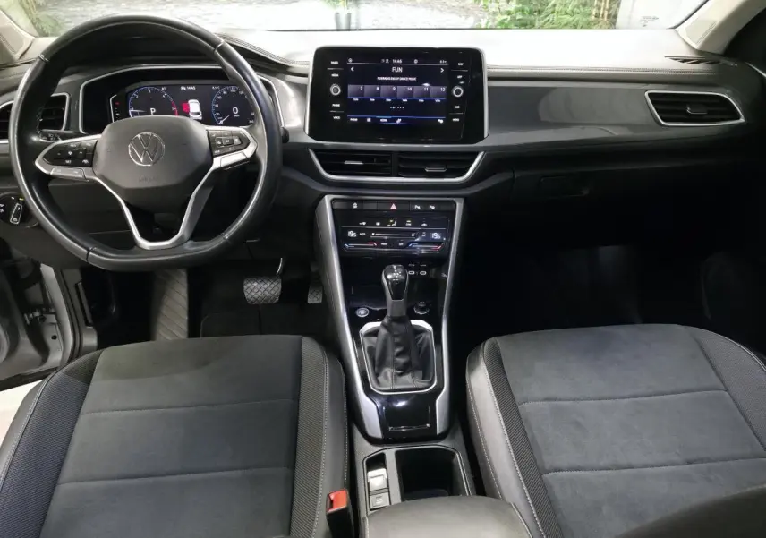 Intérieur Volkswagen T-Roc 2022, vue avant centrée sur tableau de bord, volant cuir multifonction et écran tactile 8 pouces.