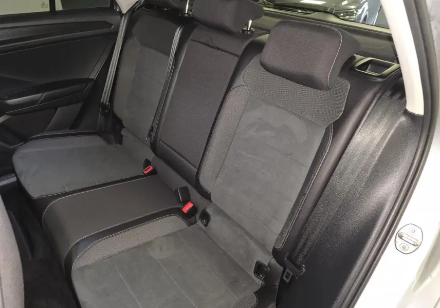 Vue intérieure de la banquette arrière en sellerie Artvelours noire du Volkswagen T-Roc gris, avec appuis-tête et ceintures visibles.