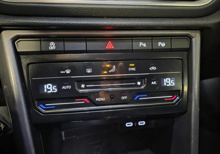 Détail du tableau de bord noir du Volkswagen T-Roc 2022 montrant la climatisation automatique bi-zone à 19,5°C.