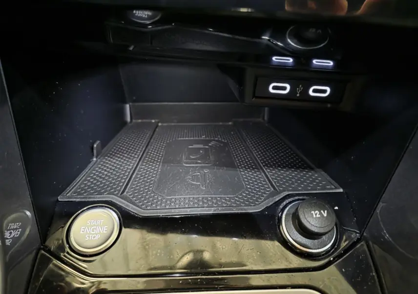 Gros plan sur la console centrale noire du Volkswagen T-Roc 2022, avec bouton start/stop et prise 12V visibles.