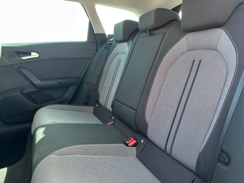Vue latérale intérieure des sièges arrière gris clair et foncé du SEAT LEON ST 2.0 TDI 115ch STYLE XL avec ceintures rouges visibles.