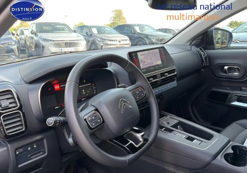 Vue intérieure côté conducteur du Citroën C5 Aircross gris platinium, avec tableau de bord et écran tactile central visibles.