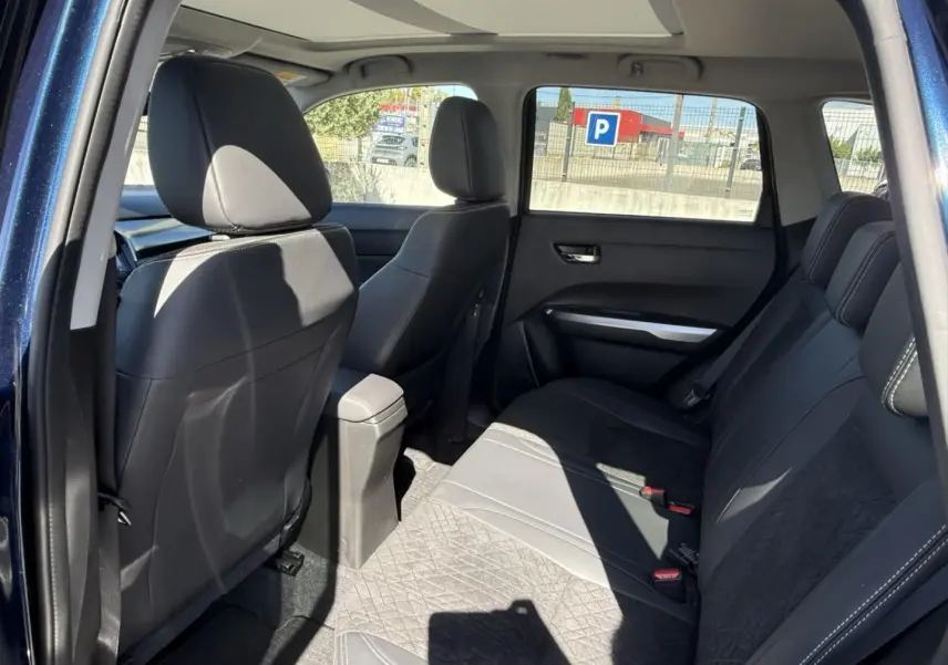 Intérieur arrière du Suzuki Vitara 2025 bleu foncé métal, vue côté gauche montrant les sièges en tissu et cuir noir.