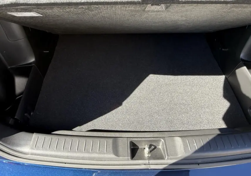 Vue plongeante sur le coffre vide du Suzuki Vitara 2025 bleu foncé métal, soulignant la finition intérieure propre et fonctionnelle.