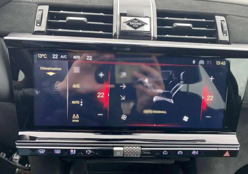Tableau de bord du DS7 Crossback 2024 en gris foncé, vue frontale centrée sur l'écran tactile de climatisation et boutons.